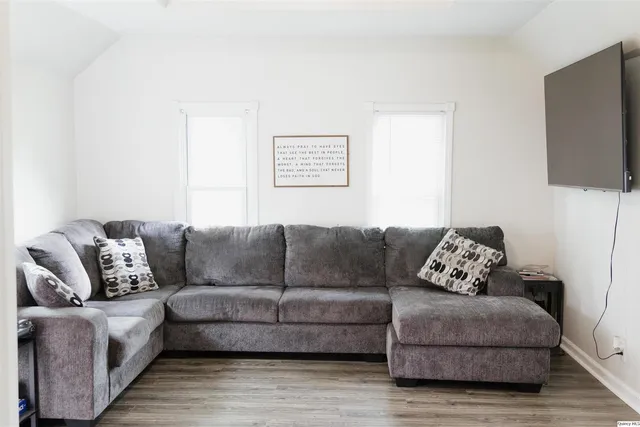 a living room with furniture a flat screen tv and a couch