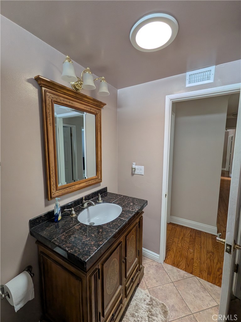 15739 Lone Ridge Place La Mirada, CA 90638 - Photo 21 of 39 a bathroom with a granite countertop sink and a mirror
