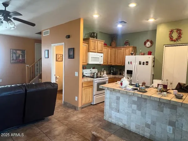 a large kitchen with stainless steel appliances kitchen island granite countertop a refrigerator and a stove
