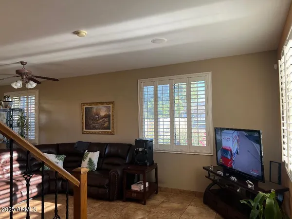 a living room with furniture a flat screen tv and a window