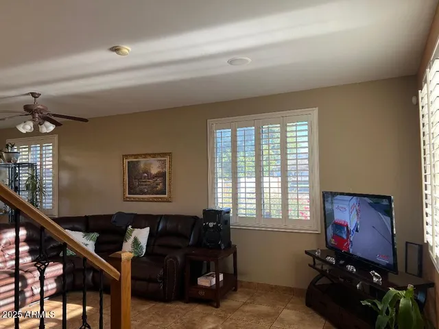 a living room with furniture a flat screen tv and a window