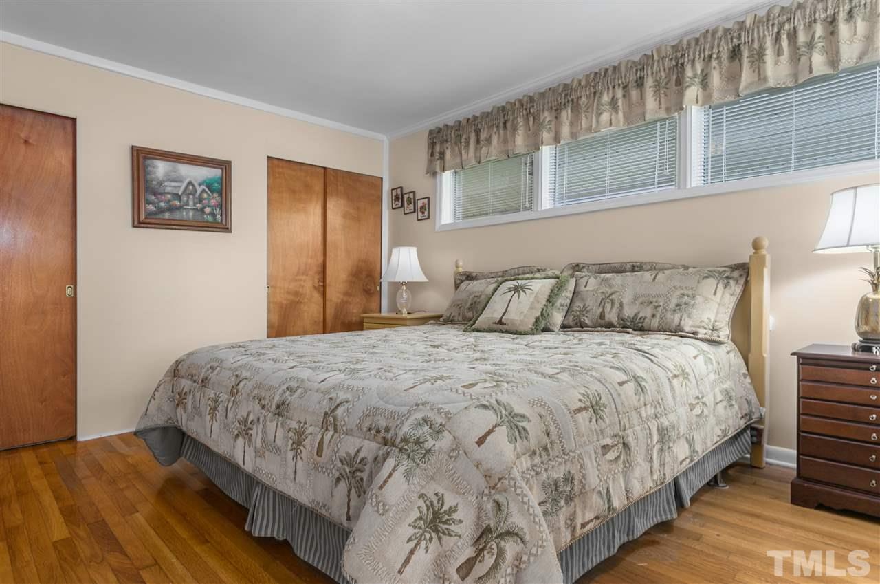5270 Six Forks Road Raleigh, NC 27609 - Photo 27 of 30 a bedroom with a bed and wooden floor