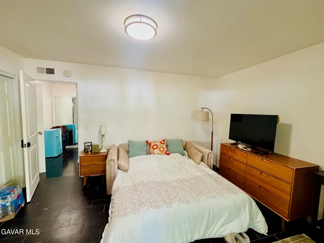 a bedroom with bed and flat screen tv