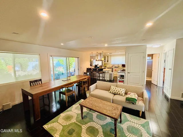 a living room with furniture wooden floor and a large window