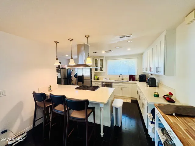 a kitchen with a dining table chairs and white cabinets