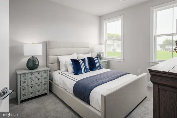 a bedroom with a bed and two windows