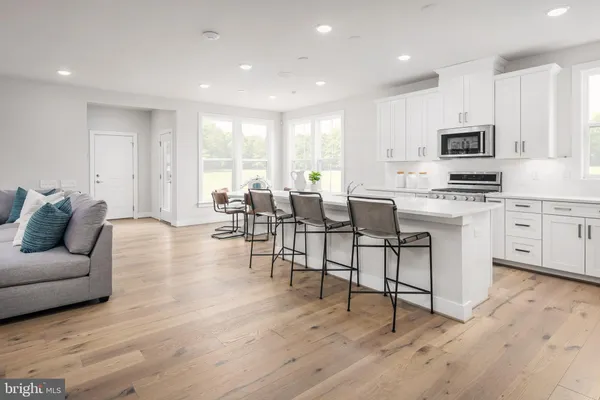 a living room with furniture a flat screen tv and kitchen view