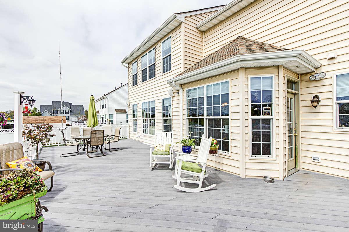 605 Sand Road Severn, MD 21144 - Photo 23 of 30 a view of a patio with table and chairs and wooden floor