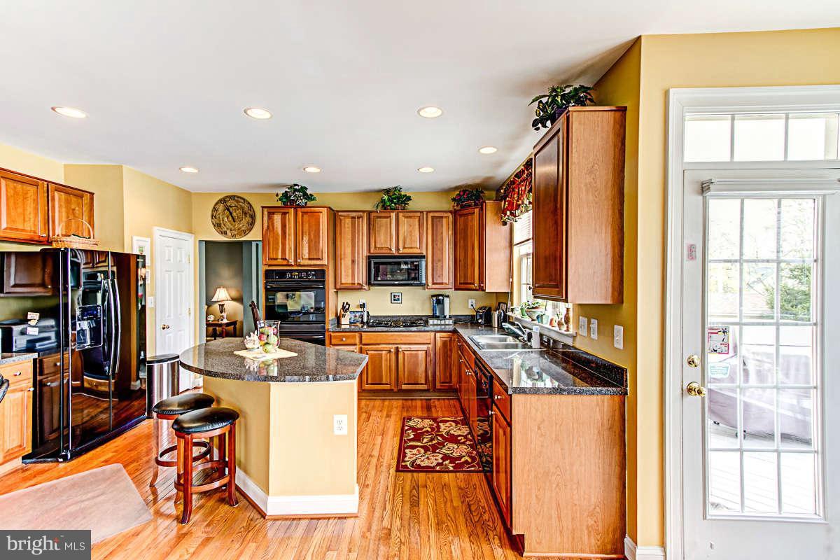 605 Sand Road Severn, MD 21144 - Photo 6 of 30 a view of a dining hall with couches and wooden floor