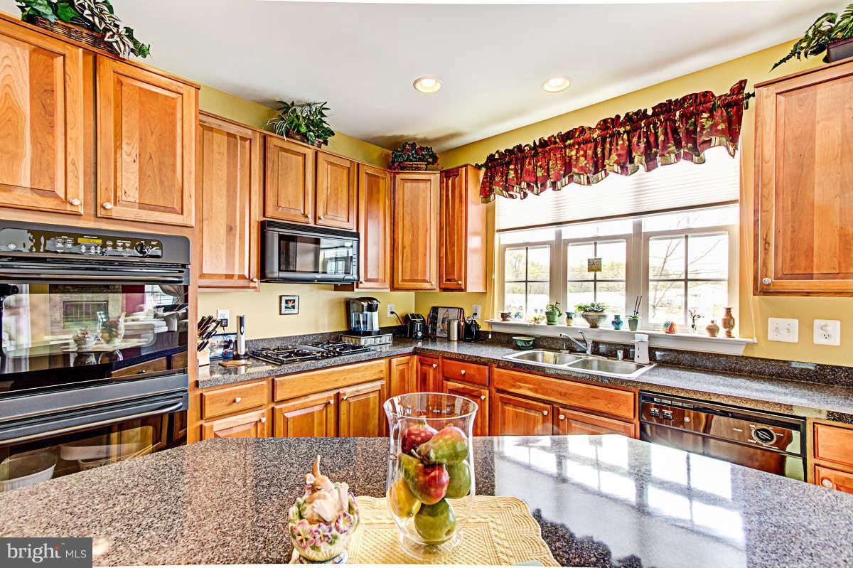 605 Sand Road Severn, MD 21144 - Photo 7 of 30 a kitchen with stainless steel appliances granite countertop a stove a sink and a microwave