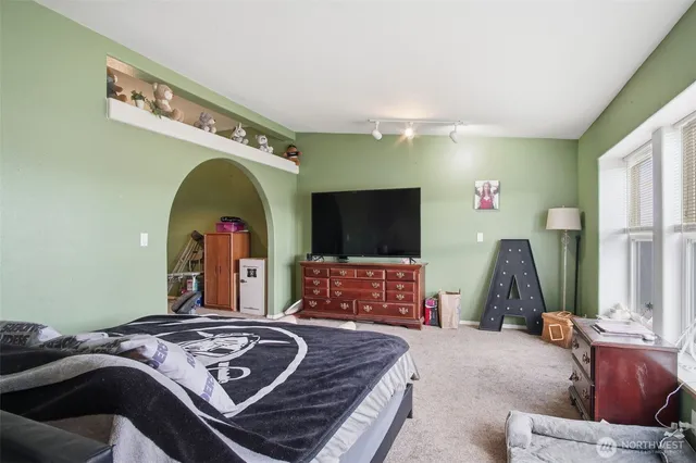 a bedroom with a bed a mirror and dresser