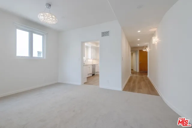 a view of a big room with windows and chandelier