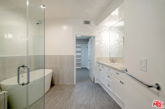 a bathroom with a tub sink and mirror