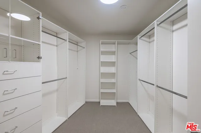 a view of walk in closet with empty racks