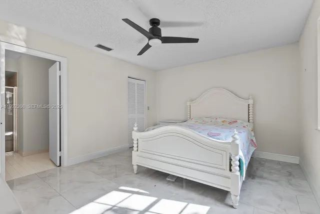 a bedroom with a bed and a ceiling fan