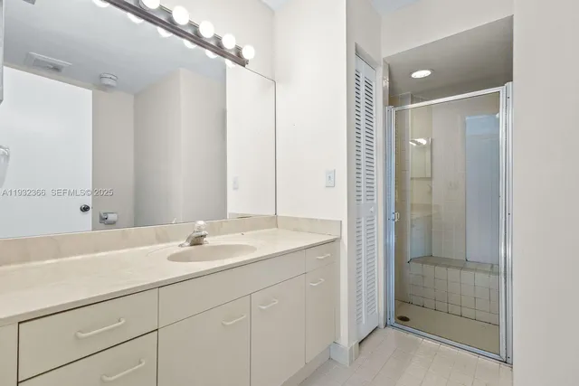 a bathroom with a shower sink and mirror