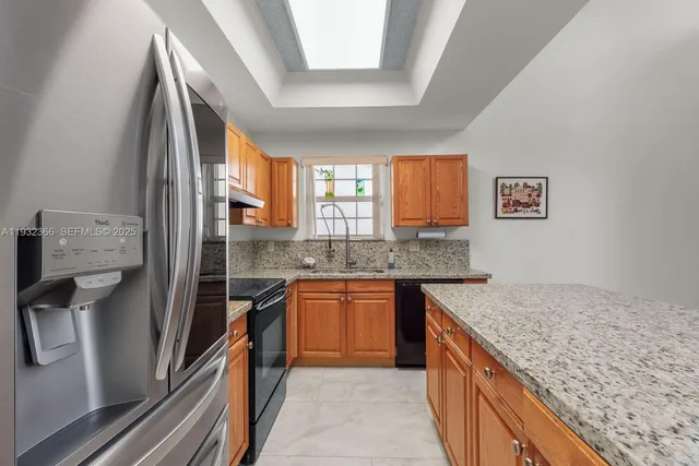 a kitchen with stainless steel appliances granite countertop refrigerator sink and stove