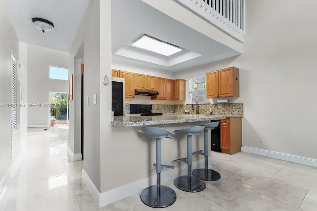 a kitchen with stainless steel appliances granite countertop a sink a stove and a refrigerator
