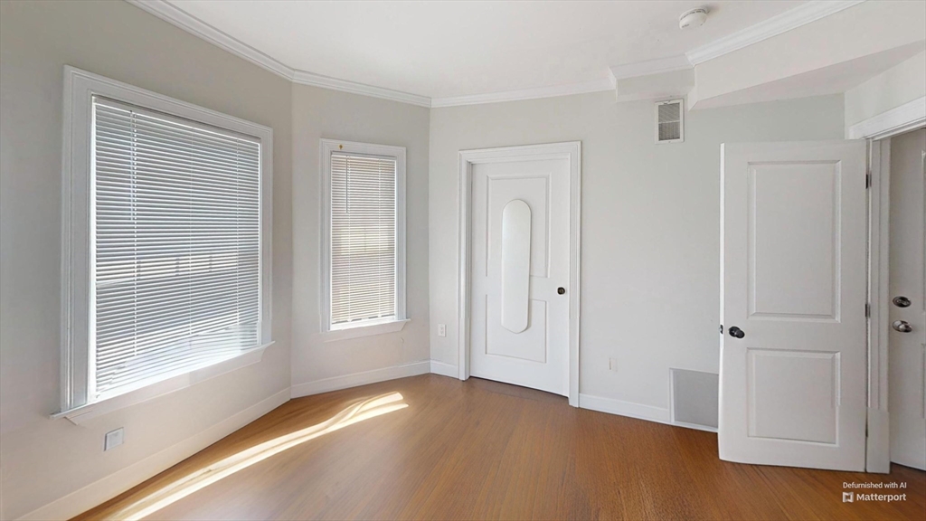 2975 Washington Street, Unit 3 Boston, MA 02119 - Photo 6 of 9 a view of an empty room with window and wooden floor