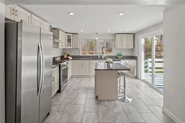 a kitchen with stainless steel appliances granite countertop a refrigerator and a stove top oven
