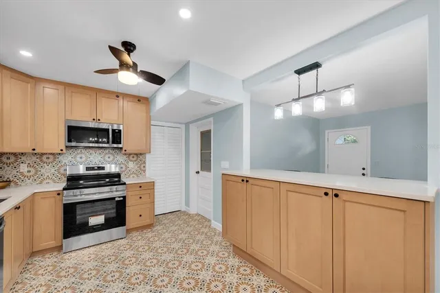 a large kitchen with stainless steel appliances granite countertop a stove a sink and a refrigerator