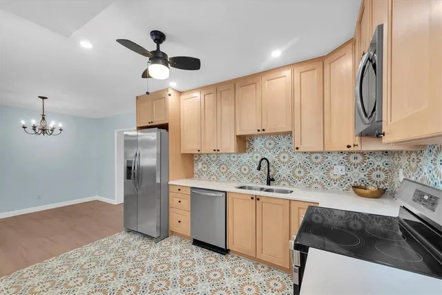 a kitchen with stainless steel appliances granite countertop a sink stove and refrigerator