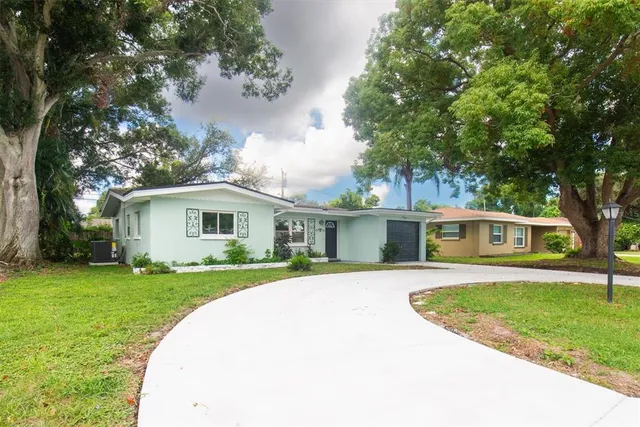a front view of a house with a yard and trees