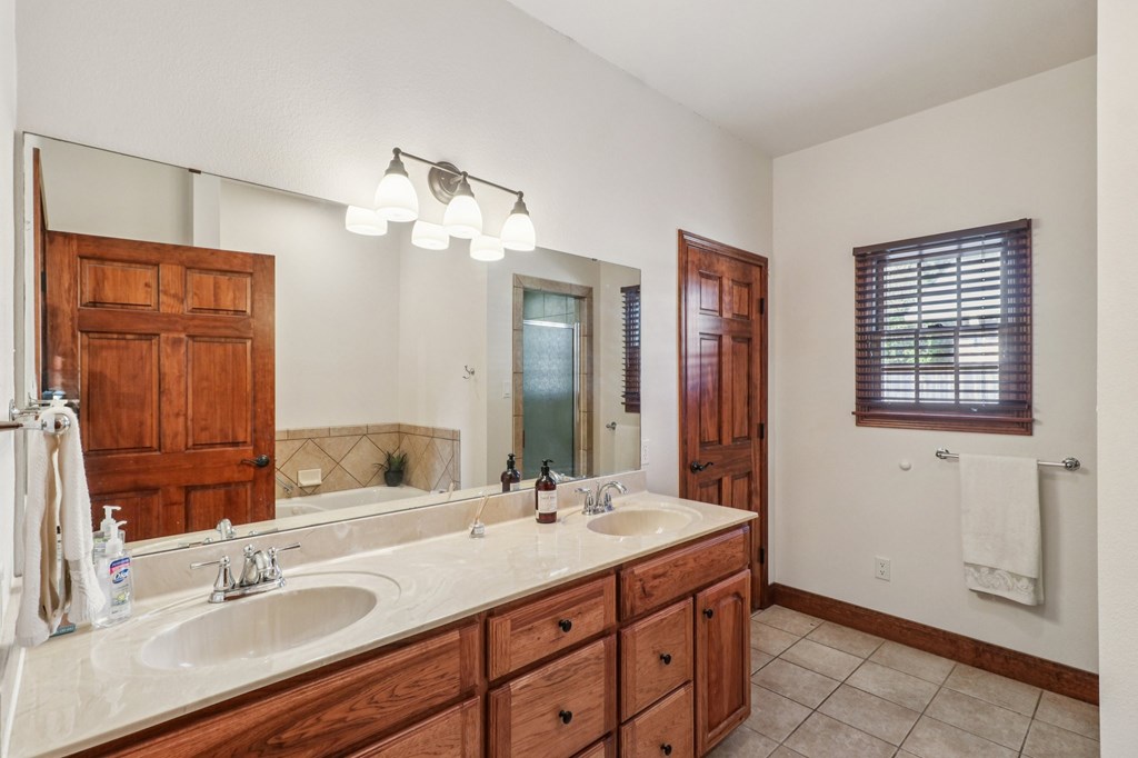802 Ave C Fredericksburg, TX 78624 - Photo 17 of 22 a bathroom with a double vanity sink and a mirror