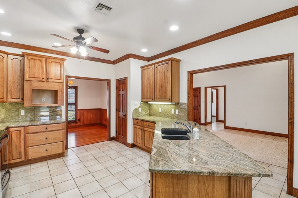 802 Ave C Fredericksburg, TX 78624 - Photo 9 of 22 a kitchen with kitchen island granite countertop a stove cabinets and living room view