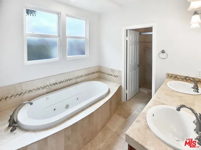 a bathroom with a granite countertop tub and a sink