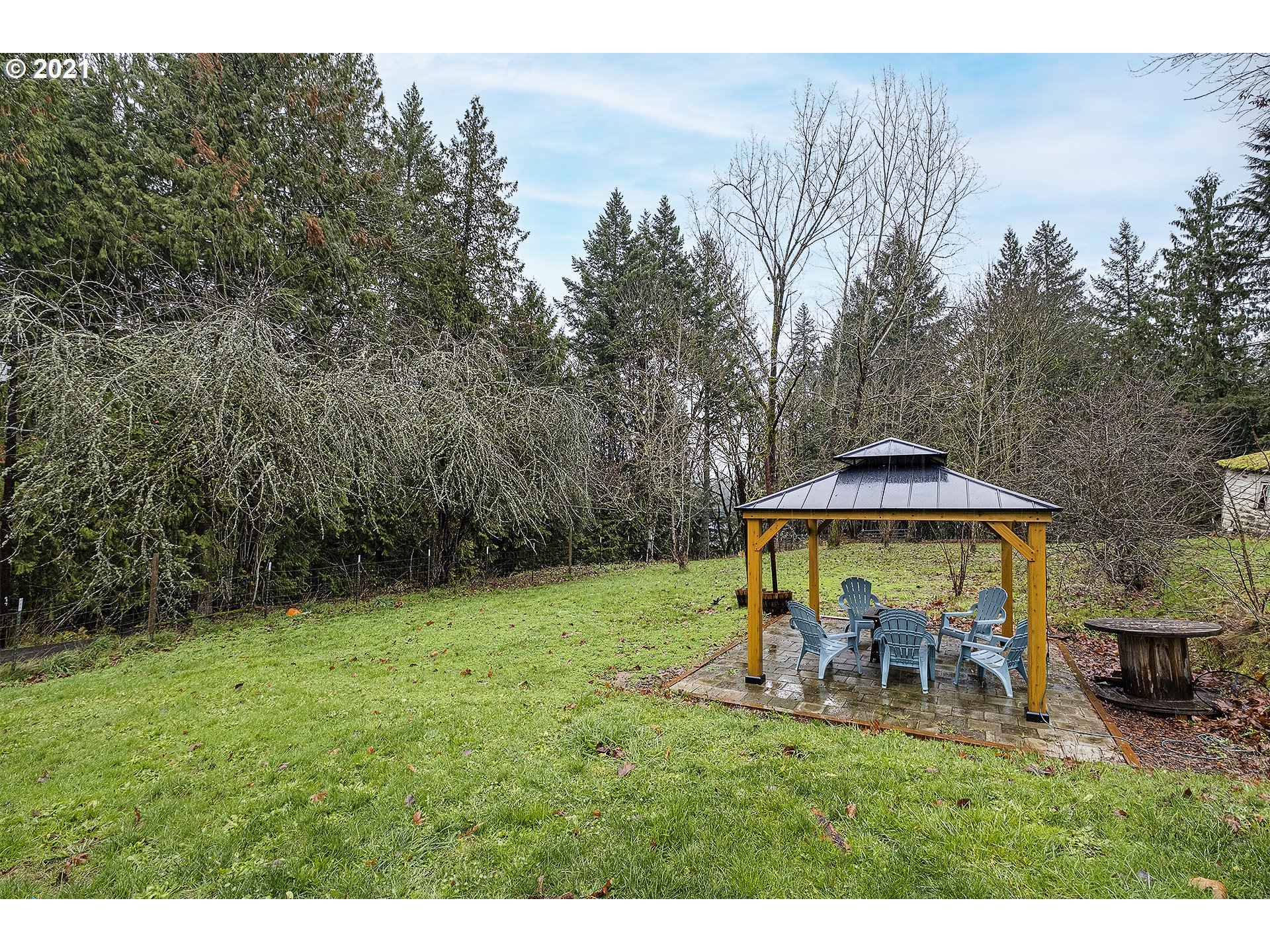 35520 Skogan Road Sandy, OR 97055 - Photo 18 of 25 a view of a backyard with table and chairs under an umbrella