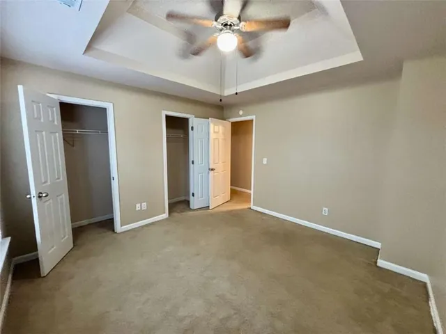 an empty room with closet and a chandelier fan