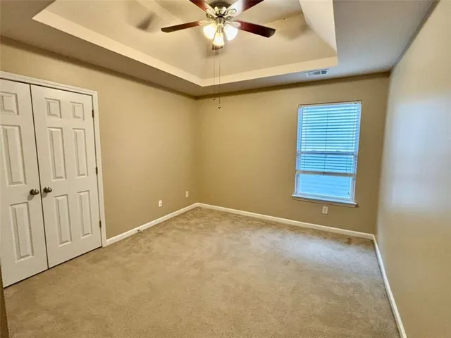 en empty room with window and ceiling fan