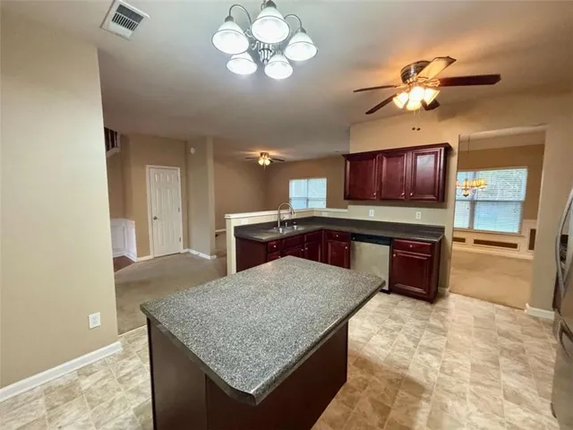 a kitchen with kitchen island a sink refrigerator and microwave