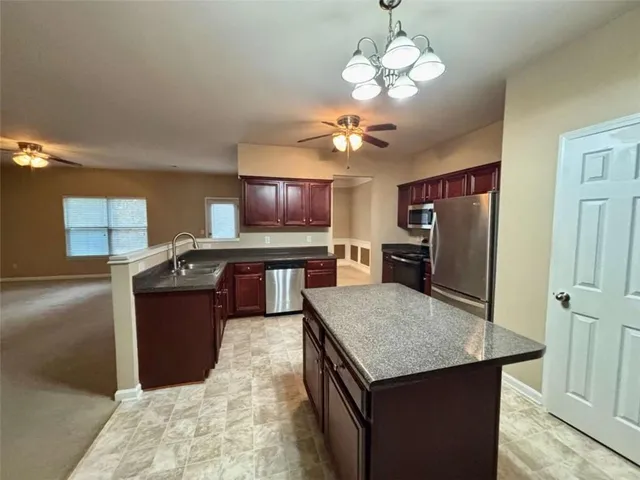 a kitchen with a chandelier appliances and furniture