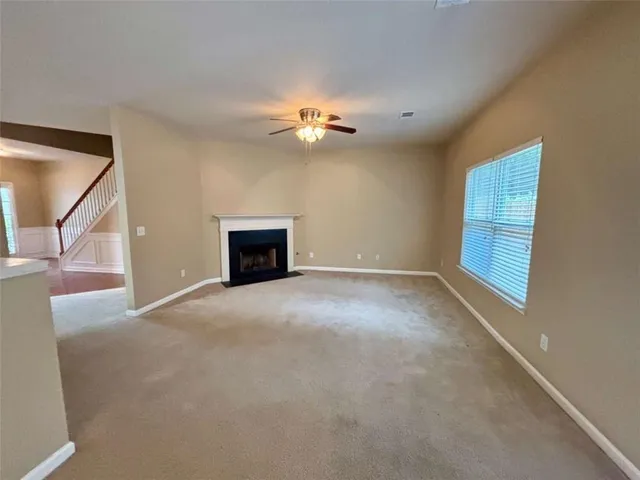 a view of a livingroom with a ceiling fan and window