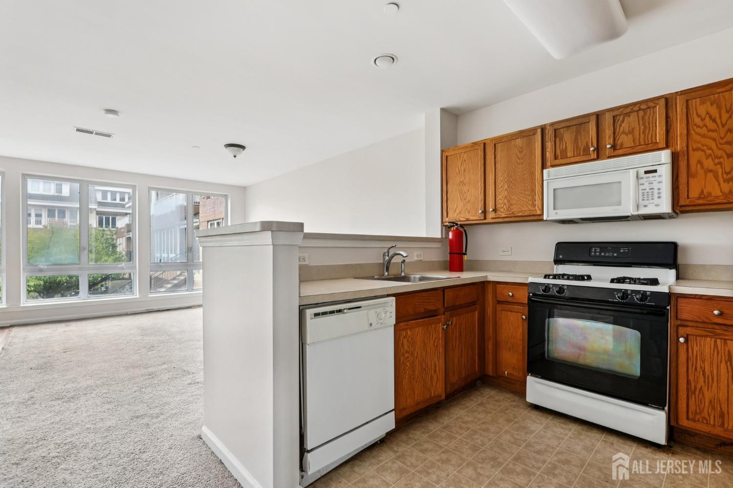 368 Rector Street, Unit 421 Perth Amboy, NJ 08861 - Photo 16 of 37 a kitchen with stainless steel appliances granite countertop a stove a sink and a microwave