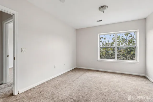 a kitchen with a refrigerator and white cabinets