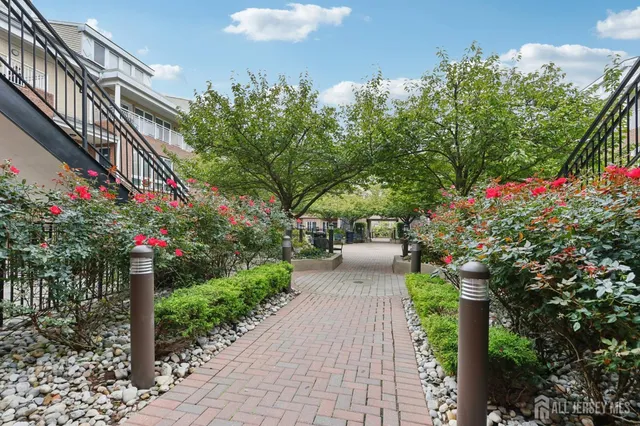 a front view of a house with a yard and fountain in middle of the house
