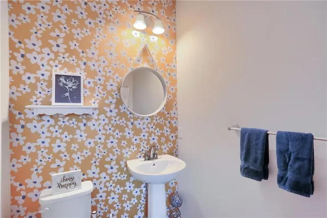 a bathroom with a sink a toilet and a mirror