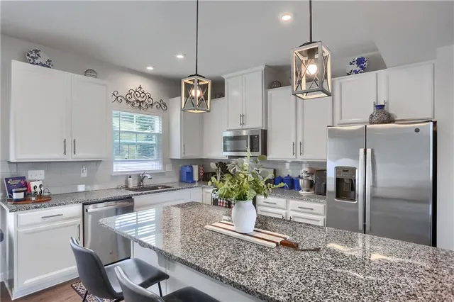 a kitchen with granite countertop a refrigerator and a sink