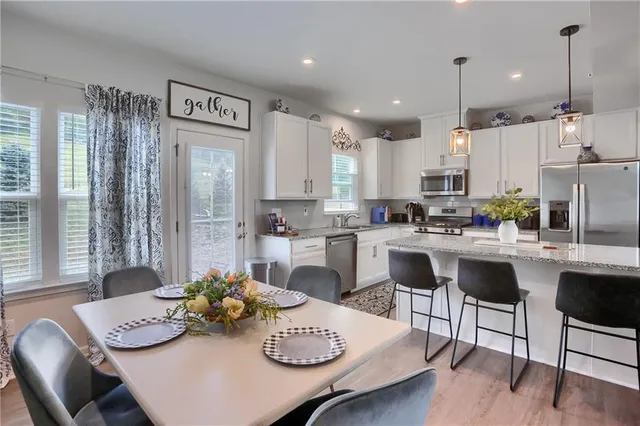 a kitchen with granite countertop white cabinets and stainless steel appliances