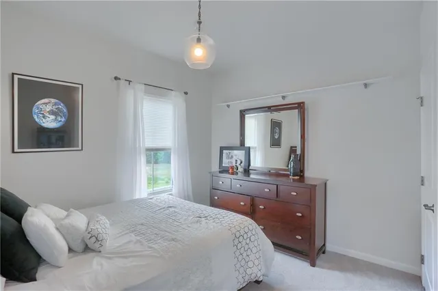 a bedroom with a bed and a lamp on dresser