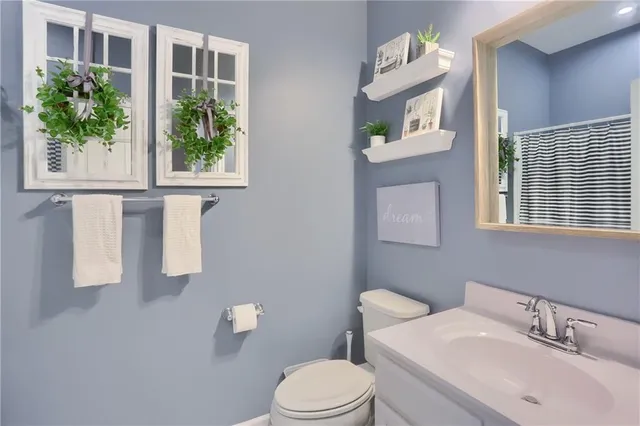 a bathroom with a sink a toilet and a window