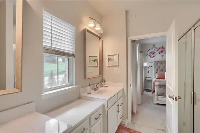 a en suite bathroom with a granite countertop sink mirror and a bathtub