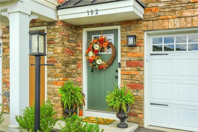 a front view of a house with a potted plant and garage
