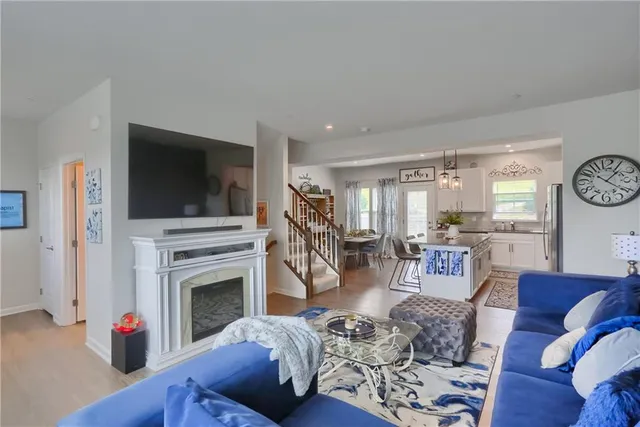 a living room with furniture a flat screen tv and a fireplace