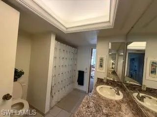 a bathroom with a granite countertop sink a toilet and shower