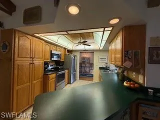 a kitchen with stainless steel appliances granite countertop a refrigerator a stove and a sink with granite countertops