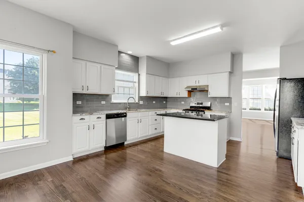 a kitchen with granite countertop white cabinets and stainless steel appliances
